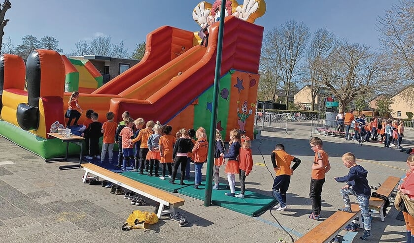 <p>Kinderen staan in de rij voor de grote glij-springkussen bij de Howiblo.</p>