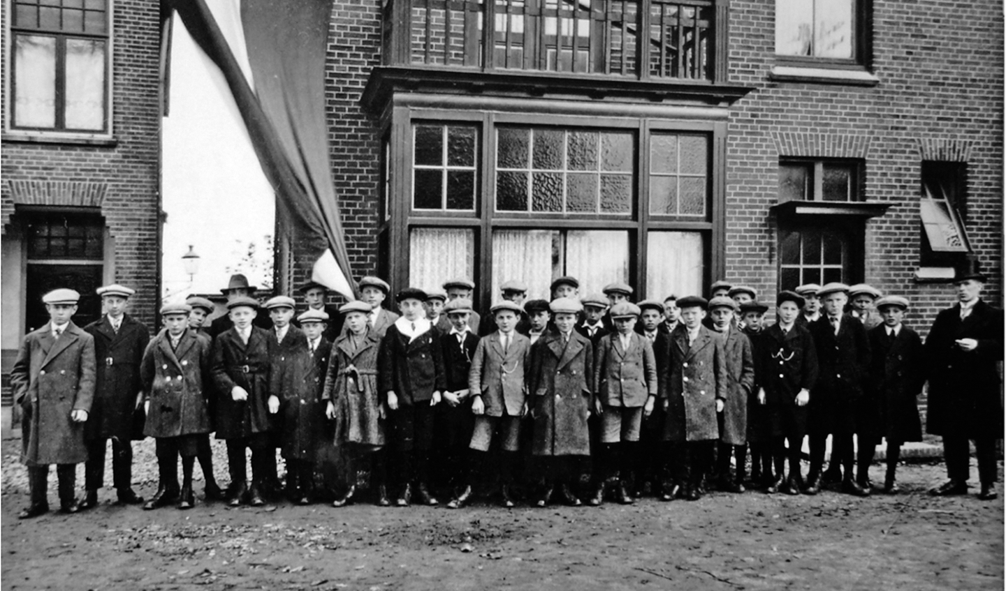 1928 - Meester Lieshout (rechts) voor zijn huis op het IJsselplein met zijn leerlingen.