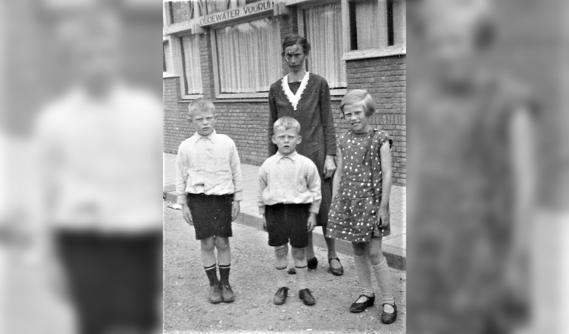 Moeder Grietje met drie van haar kinderen:Leen, Wim en Truus.De naam ‘Oudewater Vooruit’ is nog net te lezen.