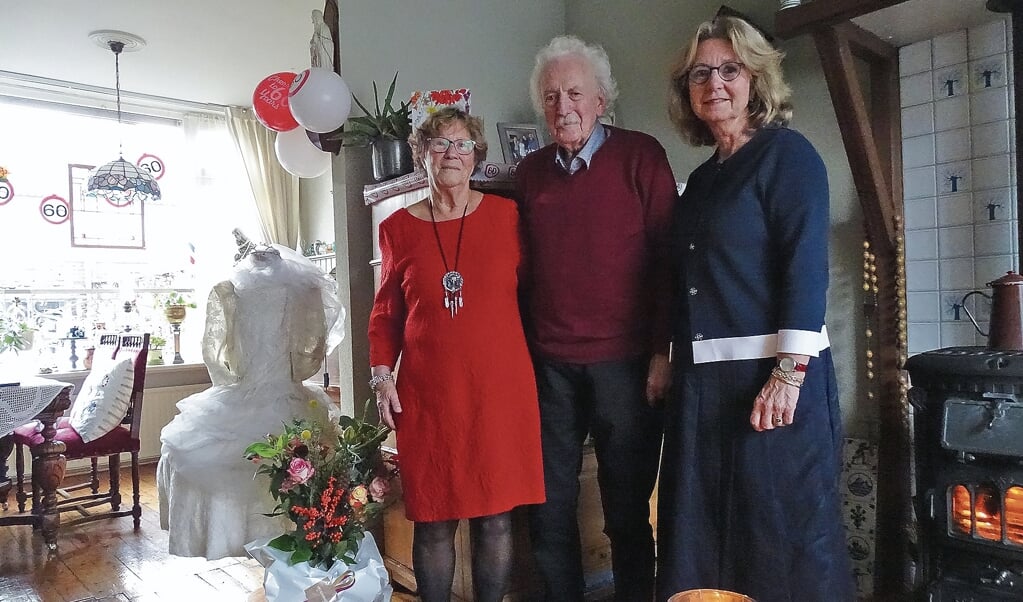 Elly en Cor Hogendoorn met waarnemend burgemeester Pauline Bouvy-Koene,naast de trouwjurk van Elly.