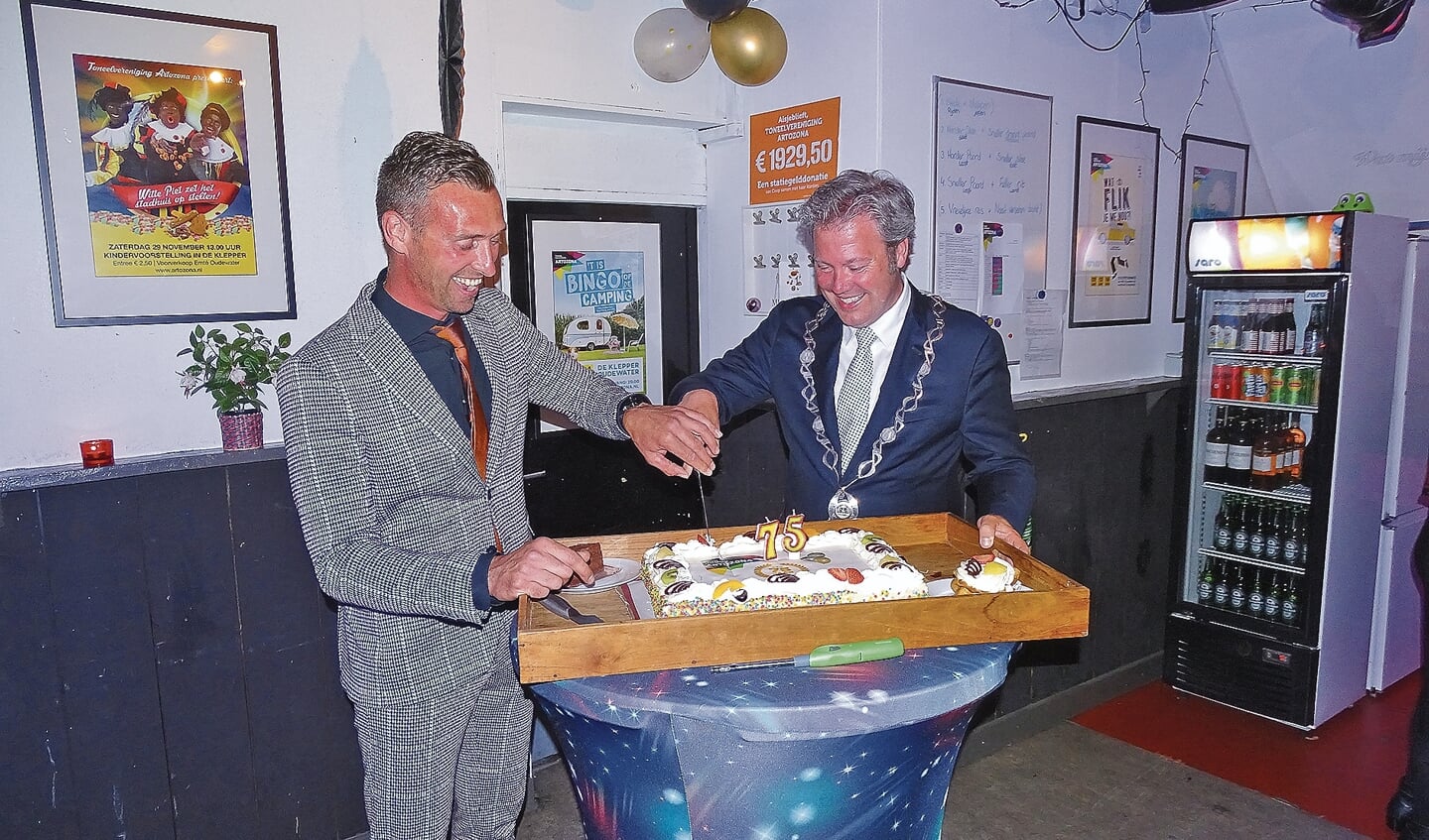 Voorzitter Menno Schoonderwoerd snijdt samen met burgemeester Danny de Vries de taart aan.