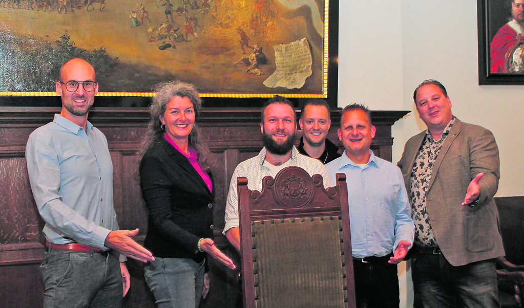 De fractie- en forumleden Ronald Gabriëls, Astrid van Jaarsveld,Gijs Hoogenboom, Mark Kruiswijk, Jelle Kuiper en Albert Griffioenstaan uitnodigend met een stoel klaar om de nieuwe wethouder welkom te heten.