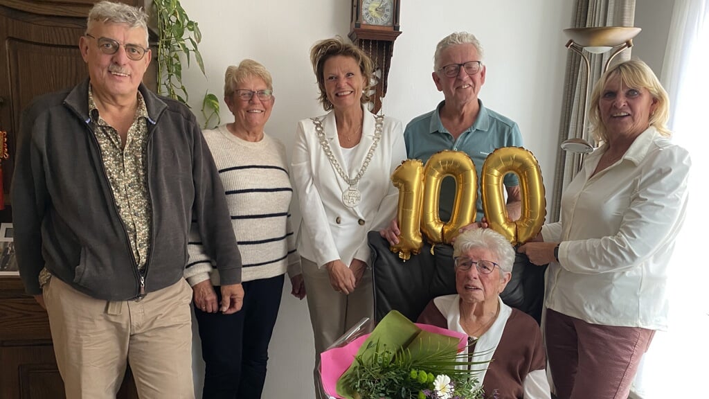 Mevrouw Van der Sluijs-van der Veenomringt door haar kinderenen burgemeester Petra van Hartskamp.