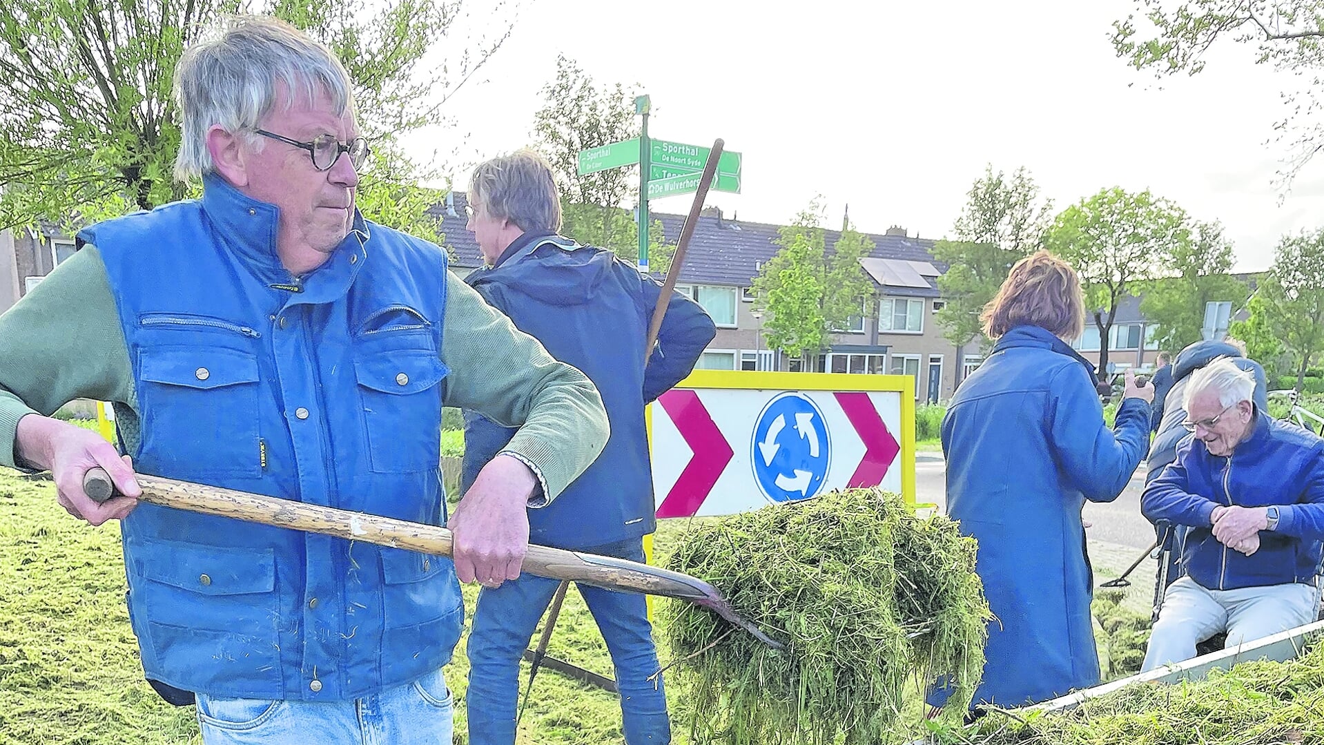 Enkele Oudewaterse senioren druk bezigmet het binnenhalen van het kuilgras.