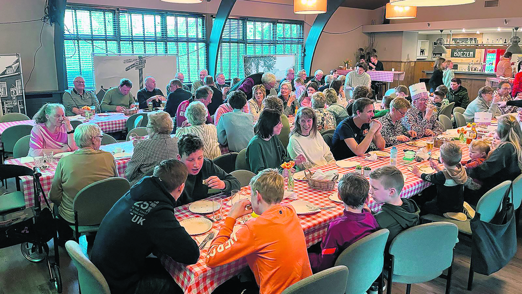 Grote lange tafels vol pannenkoekeneters in De Boezem.