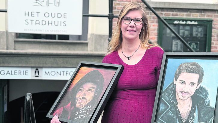 Elvira Schenk poseert met twee schilderijen die veel voor haar betekenen.