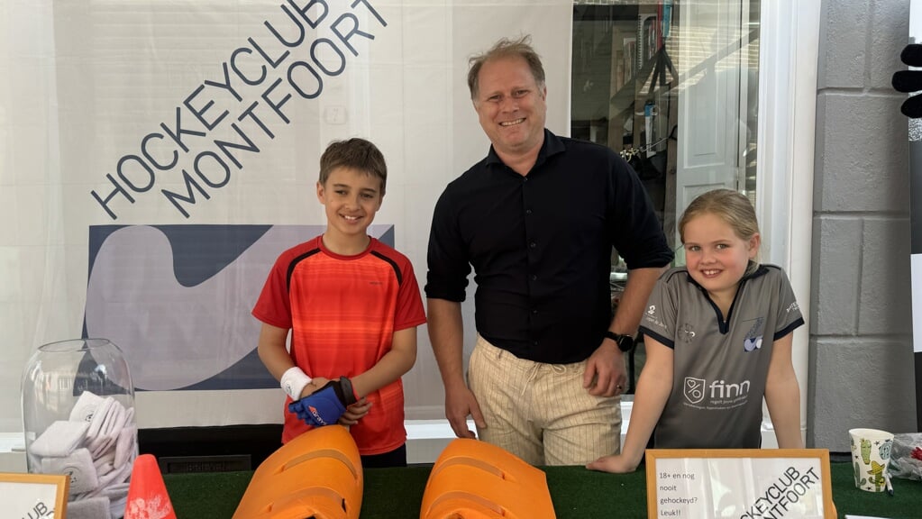 Xander met twee jonge hockeyspelers op de Lentemarkt.