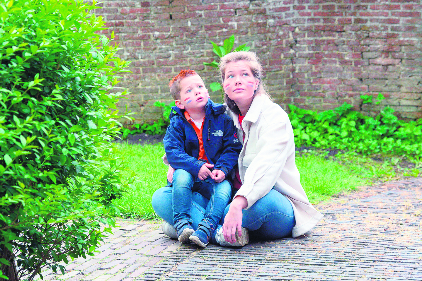 Een moeder met zoontje luisteren aandachtig naar het Wilhelmus vanaf de kerktoren.