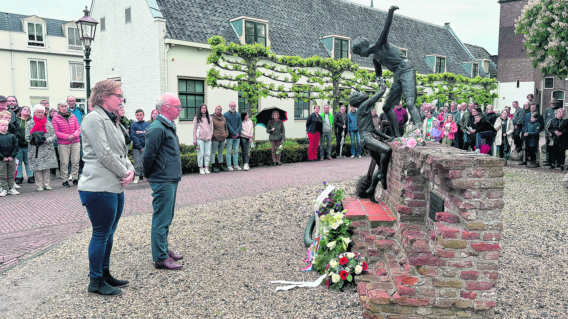 Hannelies legt een bloemenkrans neer als nieuwe voorzitster.