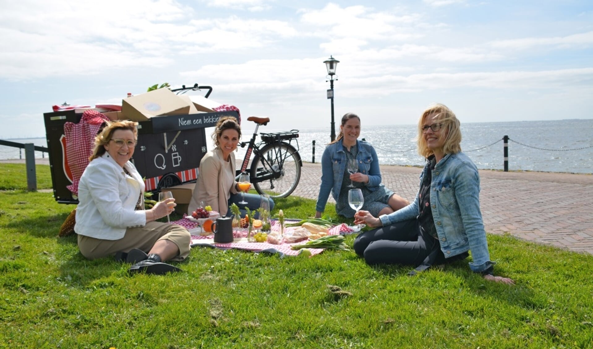  Op de foto van links naar rechts: Annerie Ester, Henria Romkes, Adrie Korf en Josu00e9 Oijevaar, genietend van de picknick onderaan de vuurtoren.