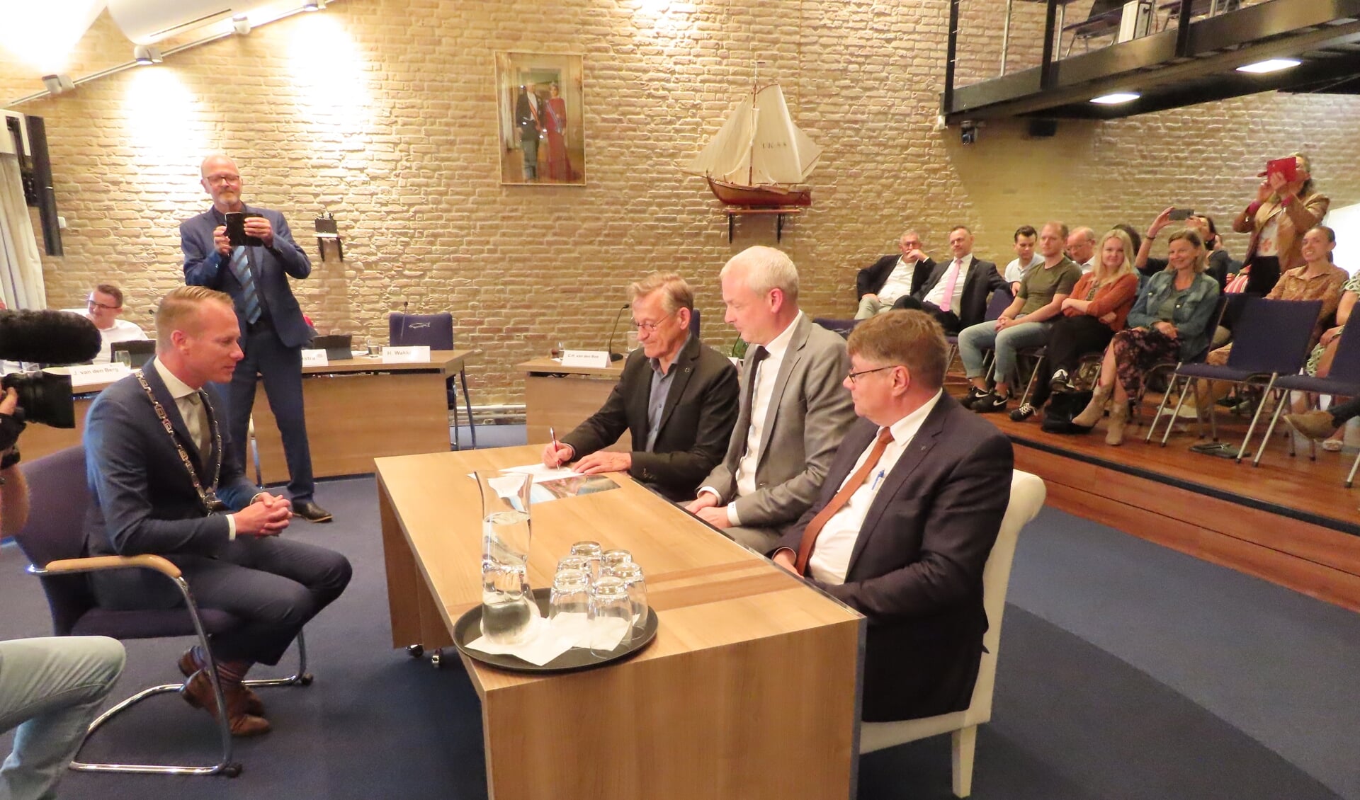 De voormannen van coalitiepartijen SGP (Jacob de Borst), ChristenUnie (Meindert Bakker) en CDA (Hans Crebas, v.r.n.l.), namen plaats in het trouwbankje om onder toeziend oog van burgemeester Cees van den Bos het coalitieakkoord te ondertekenen.