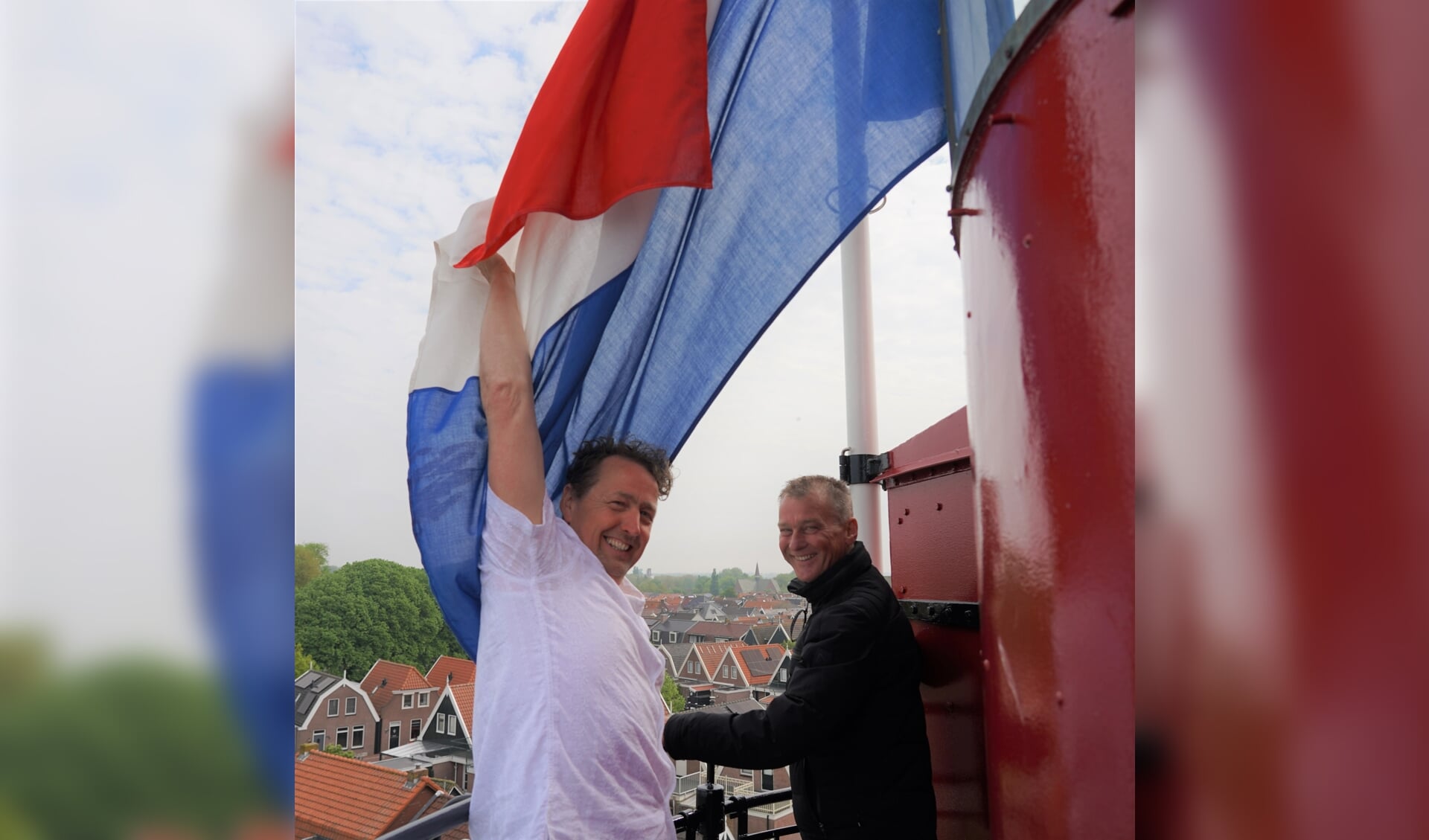 Rense Bakker (l) en Freek Brouwer hijsen de vlag.