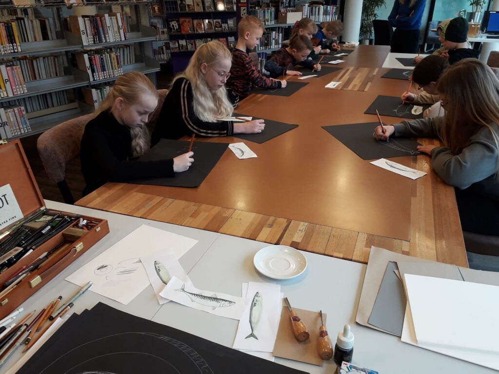 n Andries Hoekstra gaf dinsdagochtend een creatieve workshop in de bibliotheek. Hij vertelt: ,,Ze hadden de opdracht om een makreel te tekenen op zwart papier, dan moet je andersom denken. Velen ging het goed af!''