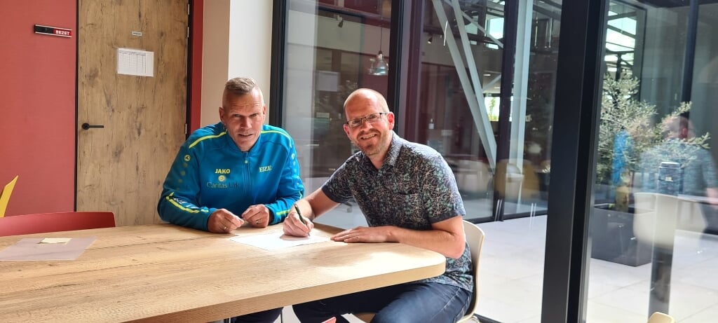n Eize van Eerde (Caritas Urk) en Johan Roskam (Werckpost) bij de ondertekening van het sponsorcontract.