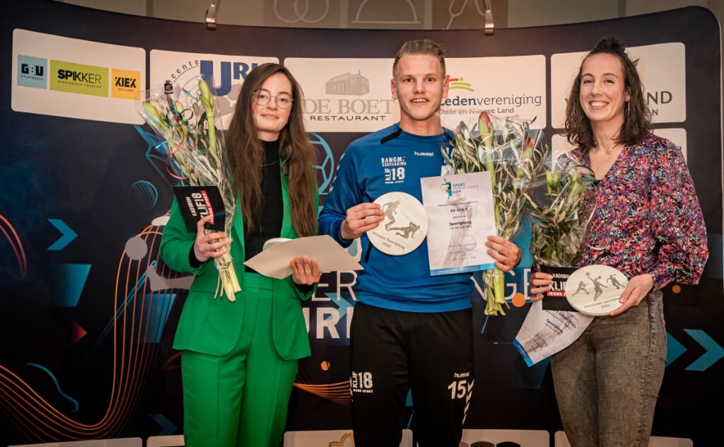 n Aanvoerder Bennie Dunnink van Urk 1 nam de prijs voor sportploeg van het jaar in ontvangst. Links Dianne de Vries (SV Urk Dames), rechts Marlies Hoorn-Verhoeff (Schol/Orca's Dames).