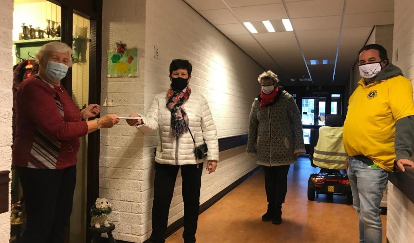 Uitreiking van de eerste kerstgroet aan mevrouw Riet van der Wiel door medewerkers van Welzijn Stichtse Vecht en Lions Club Over Holland