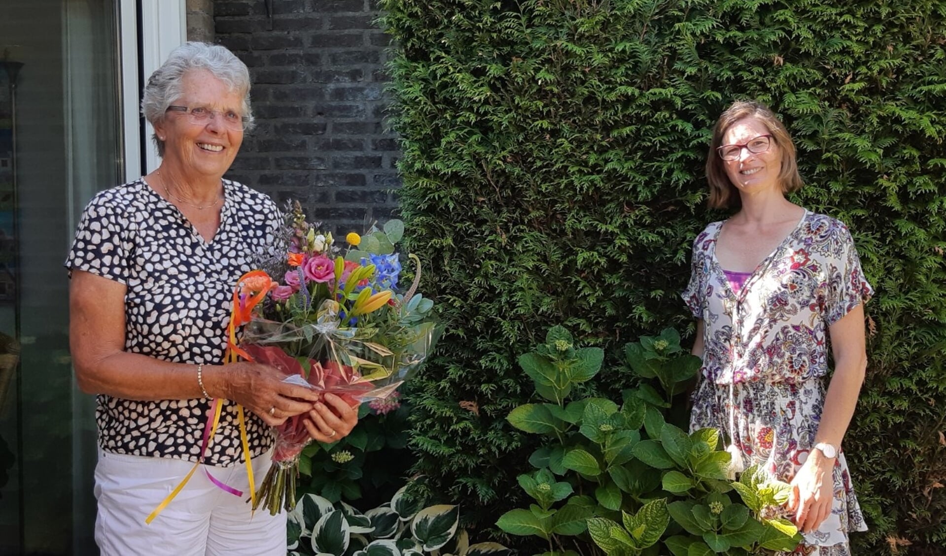 Maria Bartels (met bloemen) neemt afscheid van Annemarie Murk van WIL