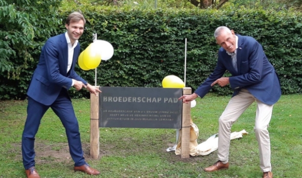 <p>Wijkwethouder Maarten van Ooijen en procurator van de Broederschap Henny Smorenburg onthullen het herinneringsbord</p>