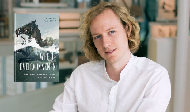 Alexander van de Bunt met de cover van zijn boek 'Wee de overwonnenen'