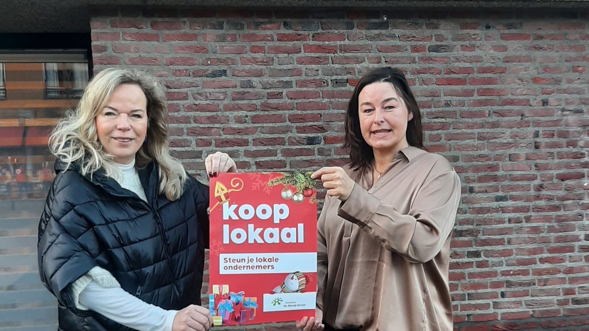  Wethouder Anja Vijselaar overhandigt de eerste Koop Lokaal poster aan Jacqueline Smit van Smit Schoenen in de Dorpstraat, lid van bestuur van Mijdrecht Dorp 