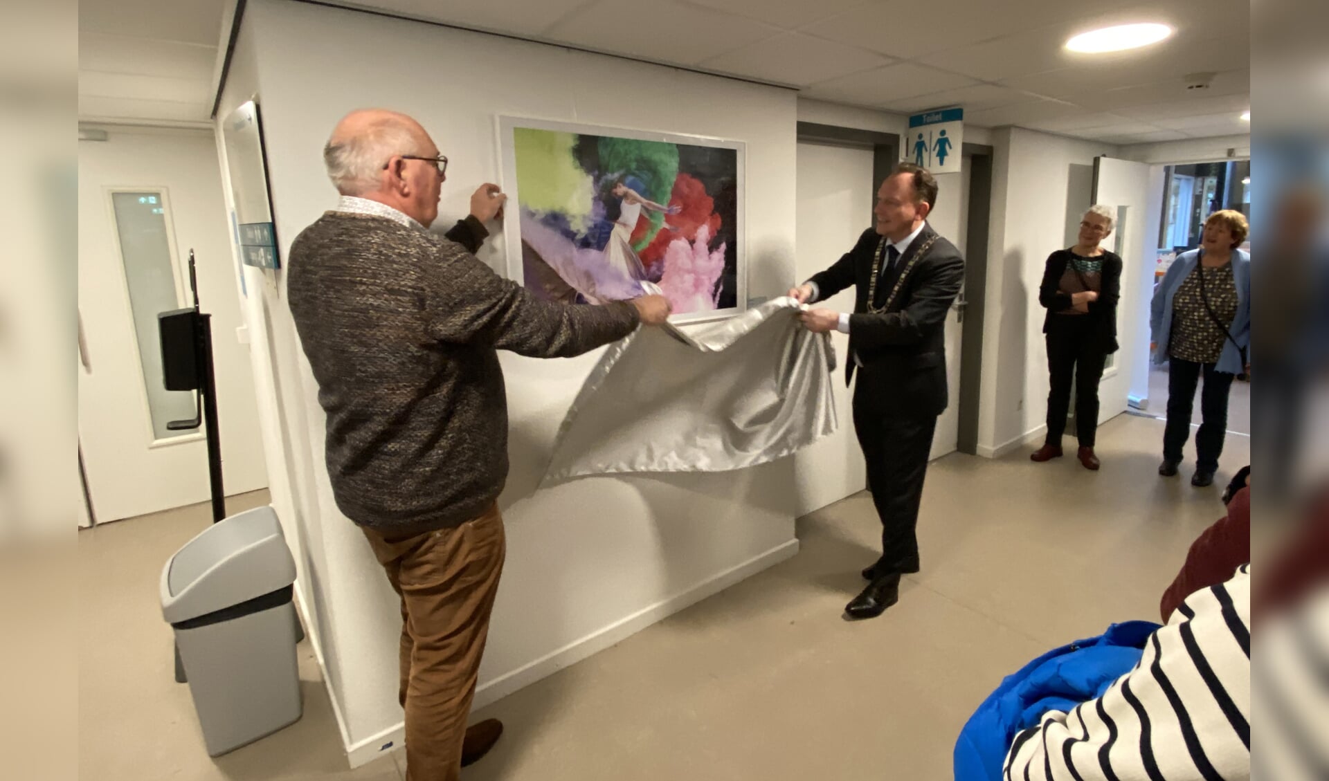 Burgemeester Ap Reinders onthult de foto die de start van de expositie vormt 