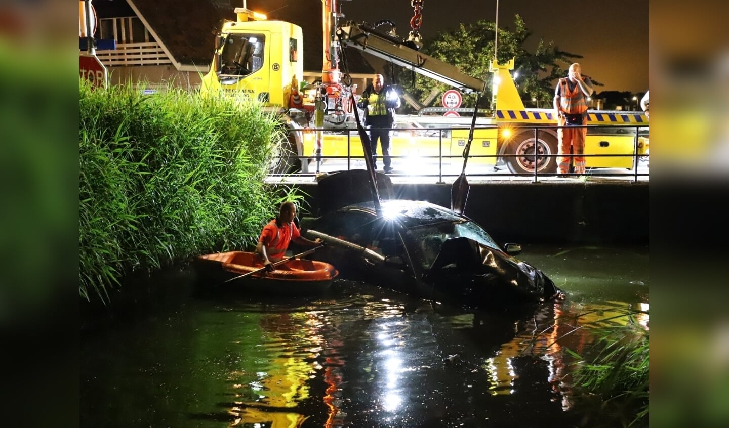 De auto wordt uit het water getakeld. (Foto: Spa Media)