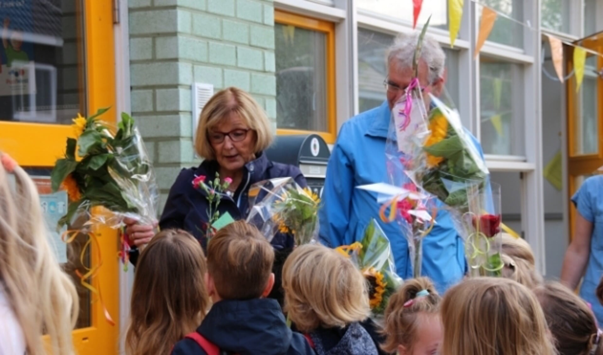 Het schoolplein stond vol kinderen met bloemen.