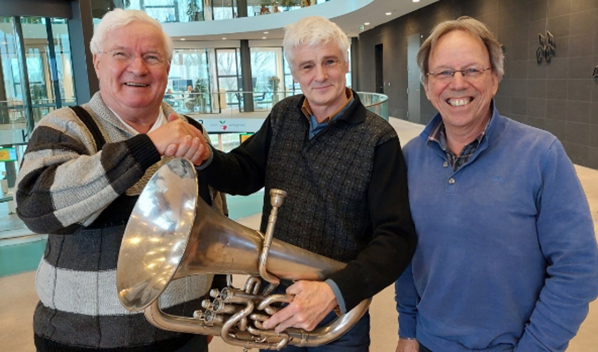 Jan in 't Veld (links) overhandigt Concordia-voorzitter René van Rooijen het euphonium. Rechts Ko Eradus, penningmeester van Concordia.