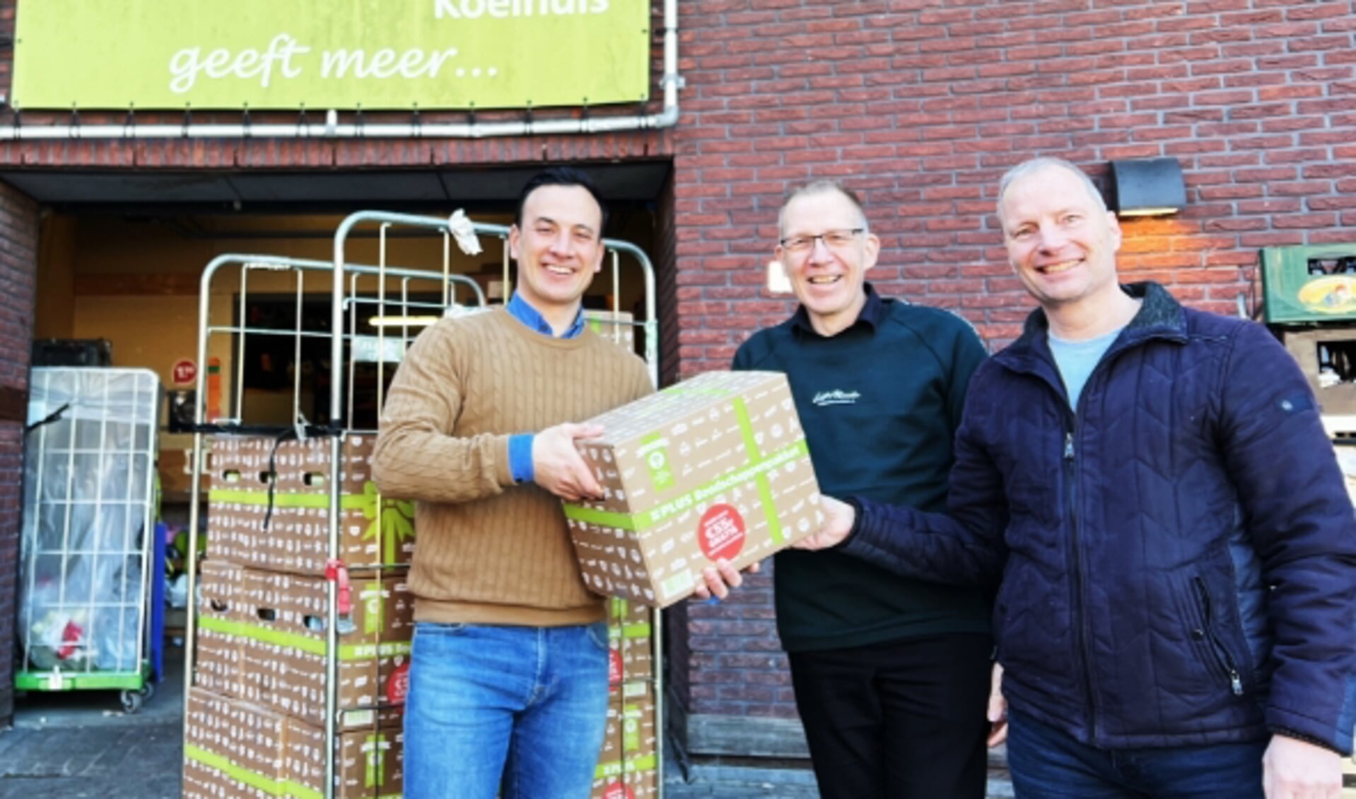 Jordy Koelhuis (links) van Plus overhandigt een pakket aan Wim de Heer (midden) en Rick Stofbergen.