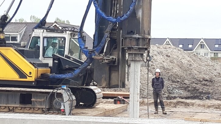 Wethouder Simon Fortuyn slaat vakkundig de eerste paal voor het nieuwbouwproject buiteNOM de grond in. (Foto: Arie van Driel)