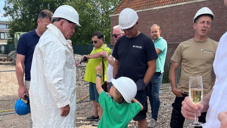 Voormalig directeur Nico Treurniet (links, in het wit) praat met zijn kleinzoon Luca na over de eerste paal die zojuist geslagen is.