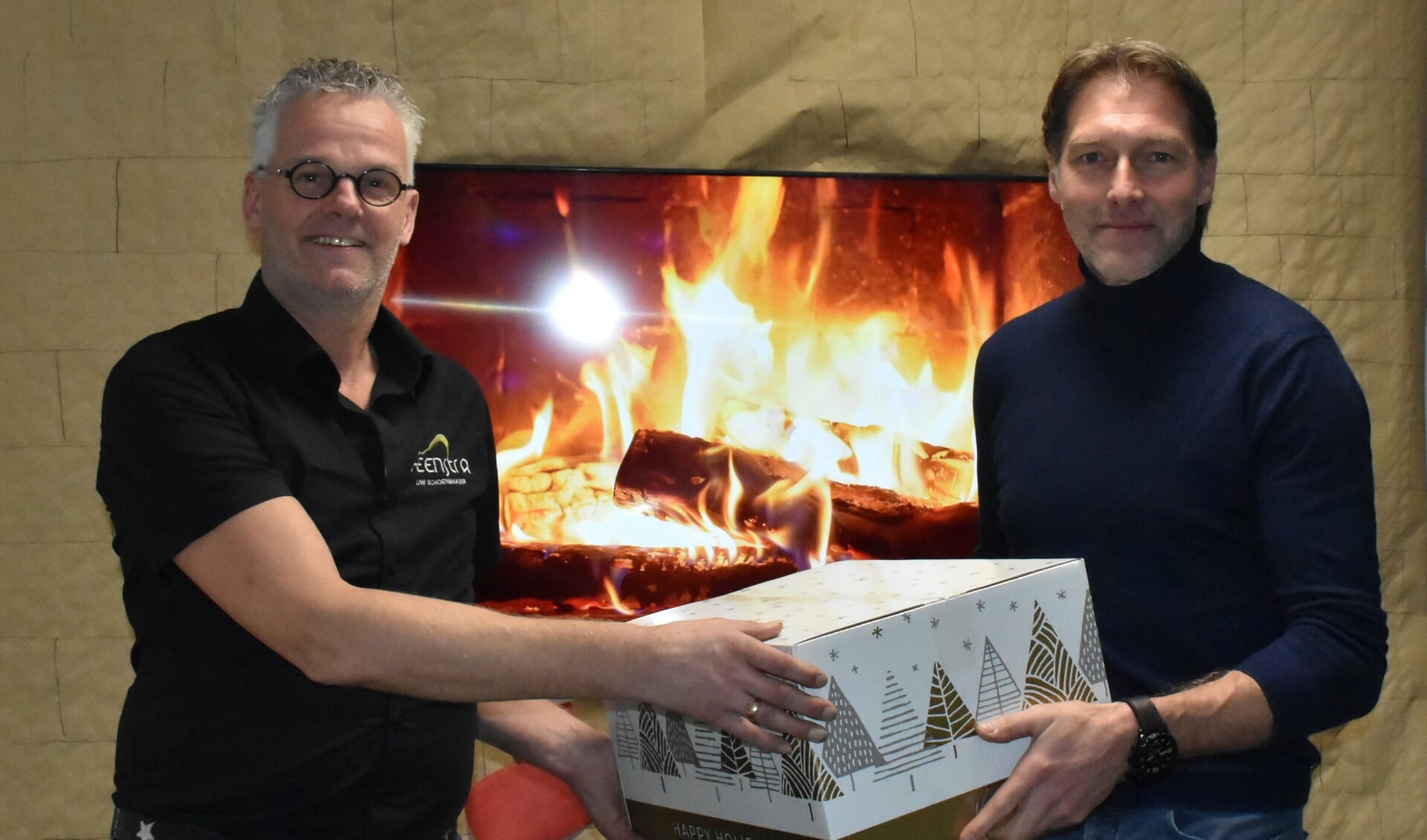 Johannes Feenstra neemt kerstpakket in ontvangst van centrummanager Peter de Vries.
