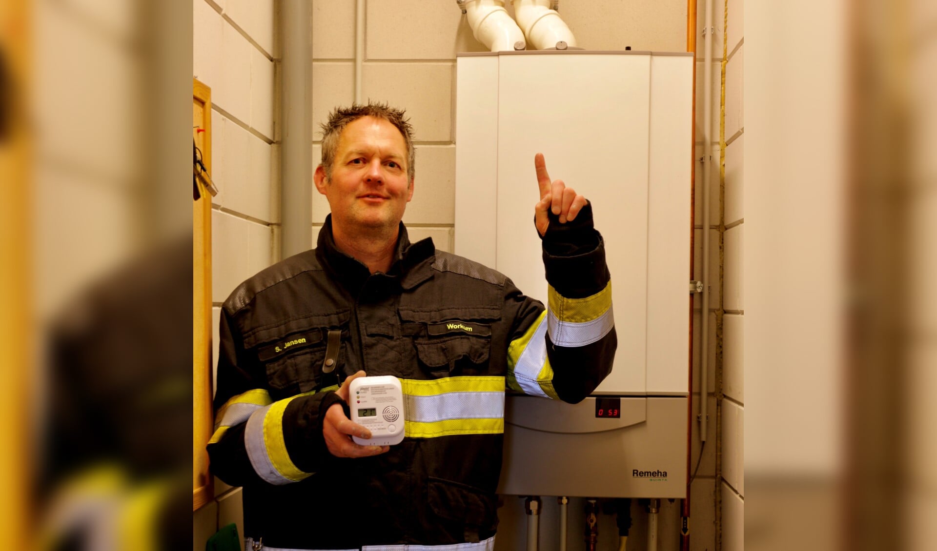 Brandweerman van post Workum wijst juiste plaats voor de co-melder aan. (Foto: Wiep Visser )