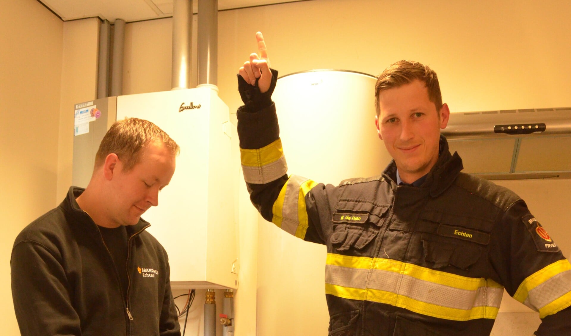 Brandweerman van post Echten wijst juiste plaats voor de co-melder aan. 