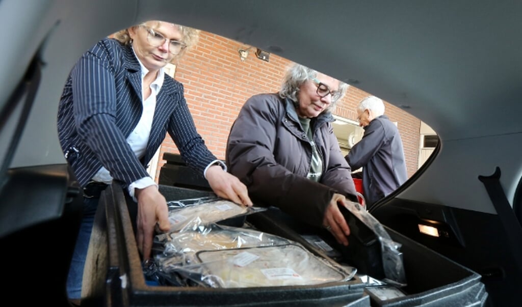 Jildou Smits (ZoZ) helpt Marja Smeding en de heer Sietzema van Voedselbank Opsterland met inladen.