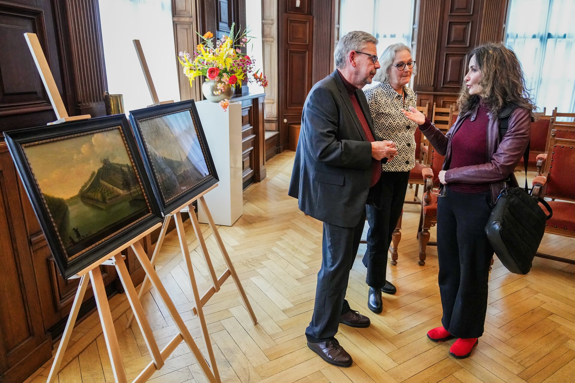Alexander Langhout, Karin Langhout en wethouder van cultuur Janita Tabak bij de geschonken schilderijen.