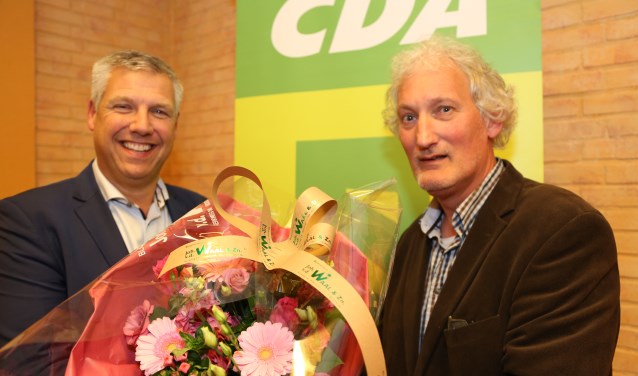 Ton Overheid (links) met bloemen van voorzitter Kees Stolk 