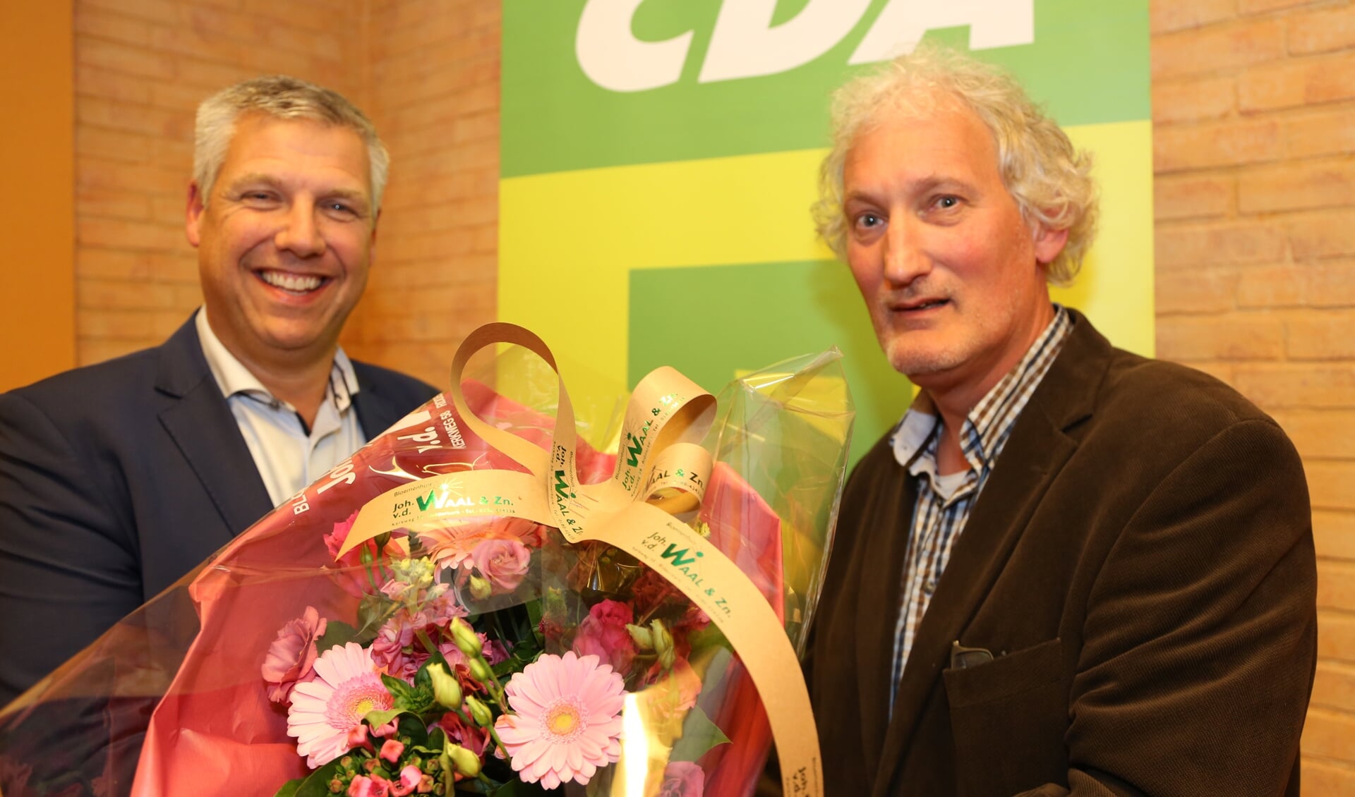 Ton Overheid (links) met bloemen van voorzitter Kees Stolk