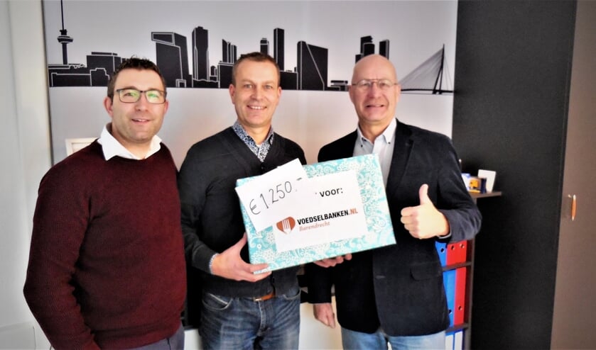 Alfred Smeitink en Werner Hagens overhandigen de cheque aan de voorzitter van de Voedselbank.