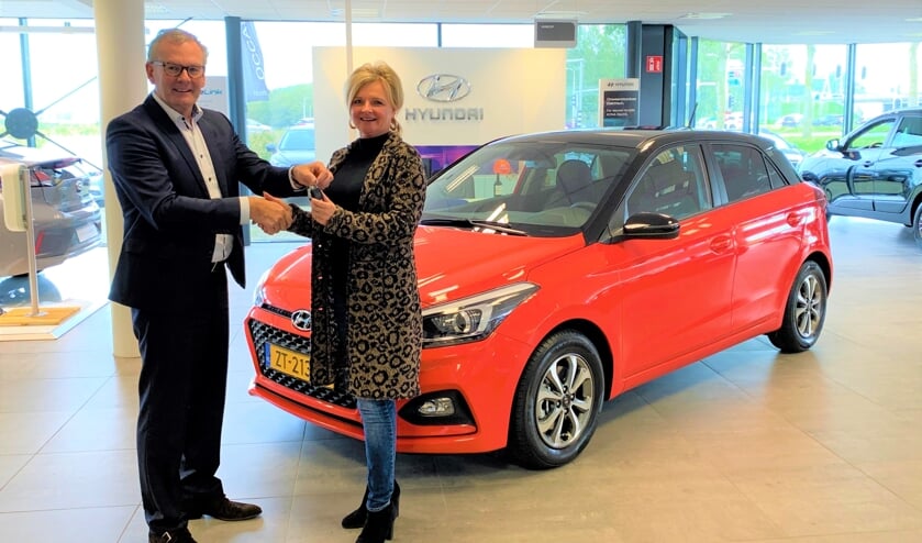 Arie Hartog overhandigt de sleutels van de Hyundai i20 aan Loes de Raaij.