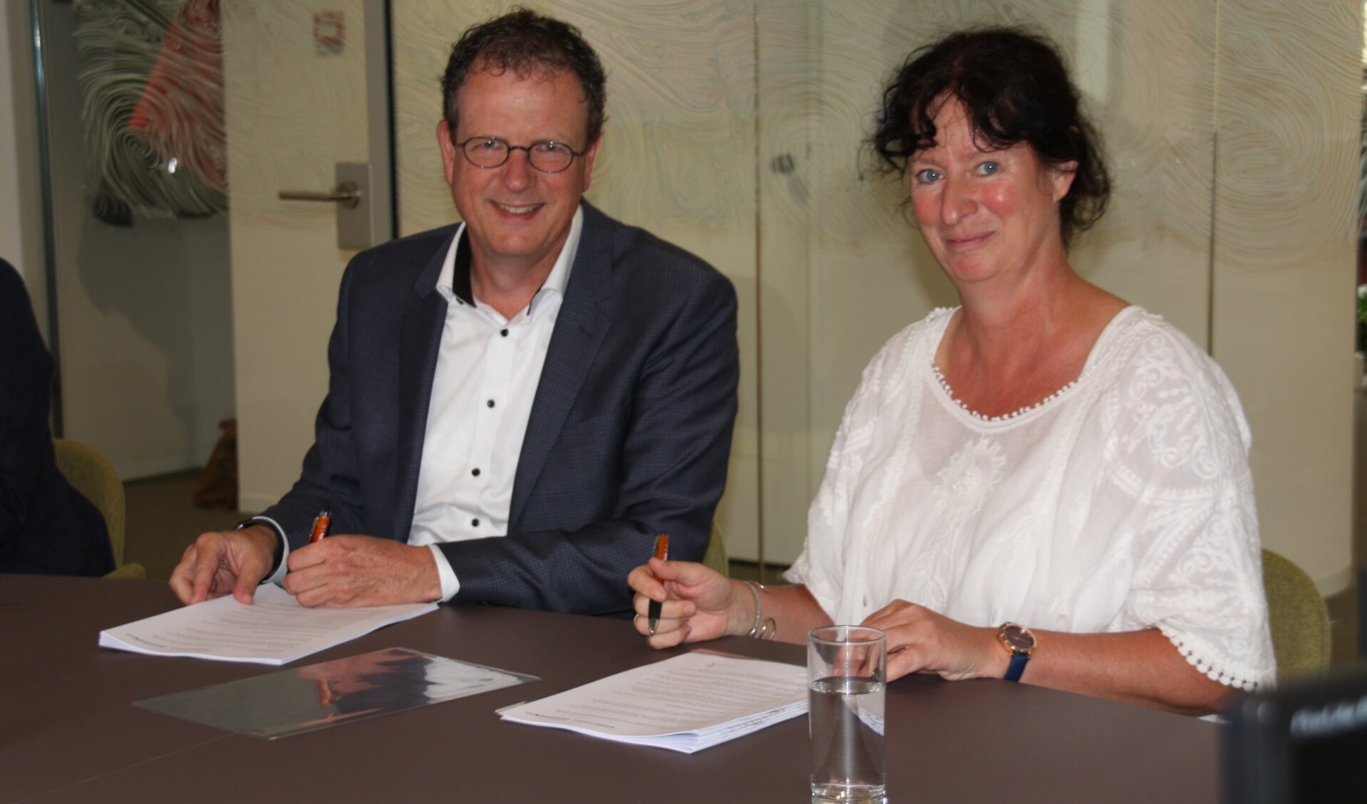 Alfred van den Bosch (Wooncompas) en Sonja Krau (IJsselmonde-Oost) ondertekenen het huurcontract