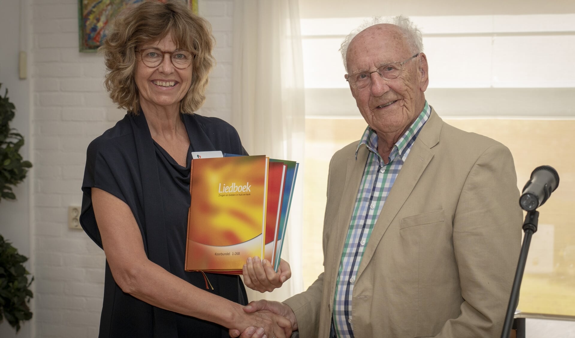 De boeken werden namens de wijkgemeenten overhandigd door Piet Laban aan directeur Bea Koops. (foto: pr)