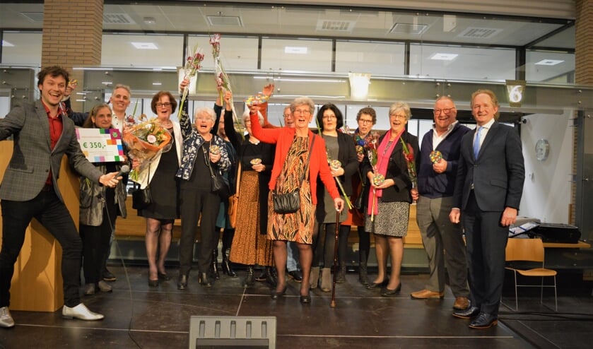 Nel van Ballegooijen (midden) op het podium met vrijwilligers van de Voedselbank. Wethouder Japenga (rechts) reikte de prijzen uit