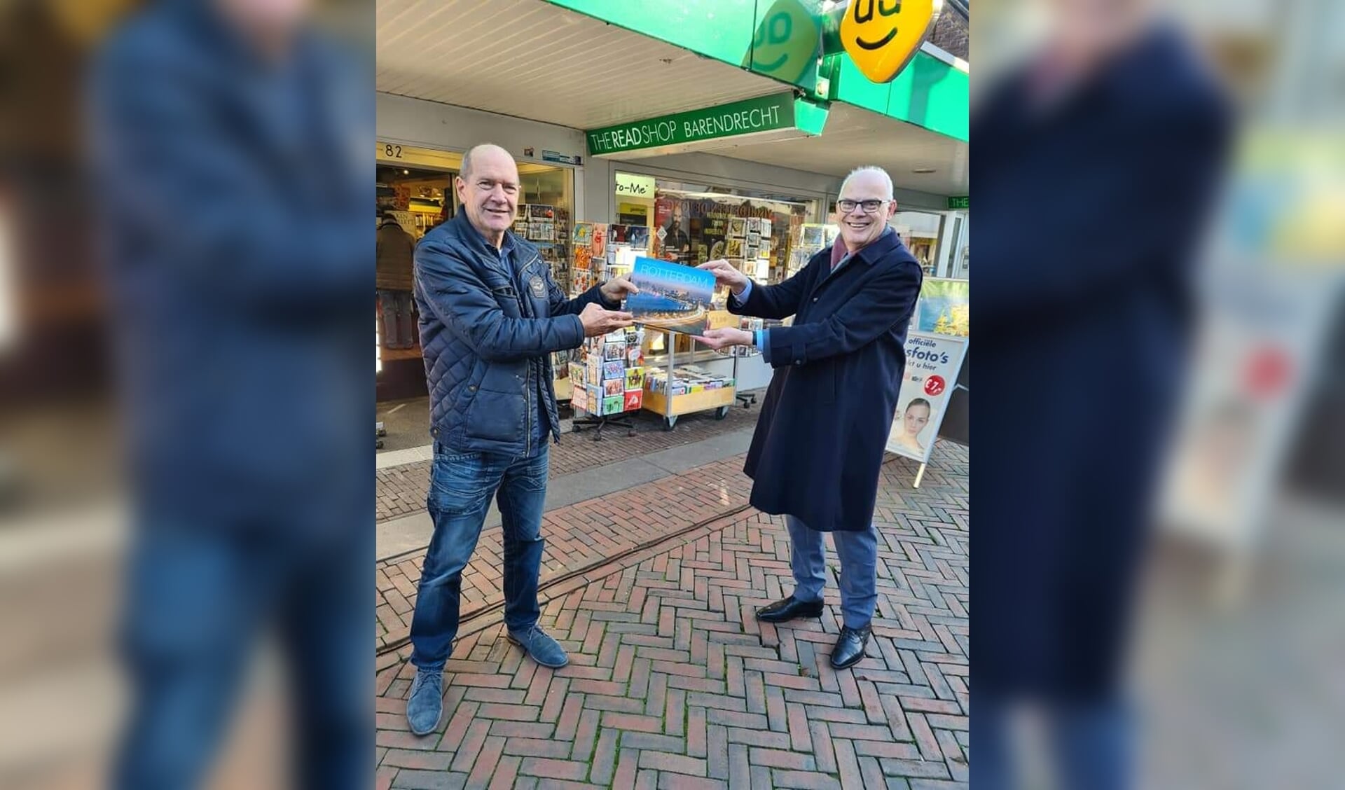 Paul Martens overhandigt een exemplaar van zijn boek aan burgemeester Jan van Belzen. 