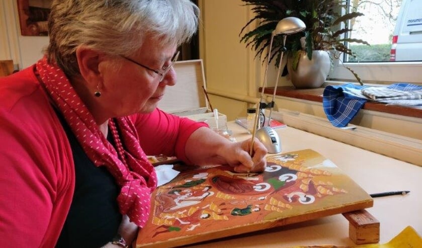Mieke Mudde bij het schilderen van een icoon
