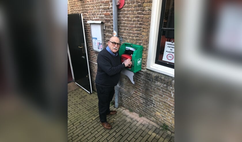 Wijkcentrum beheerder Aad Blaas bij de AED in De Boekenstal.