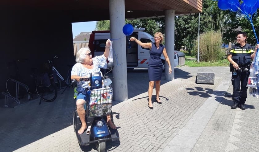 Burgemeester De Witte overhandigt samen met alle wijkagenten informatiemateriaal aan een bewoonster van De Hooge Werf. Op de foto de bewoonster van De Hooge Werf, burgemeester Jolanda de Witte en wijkagent van Rhoon-dorp Frank Koopman.