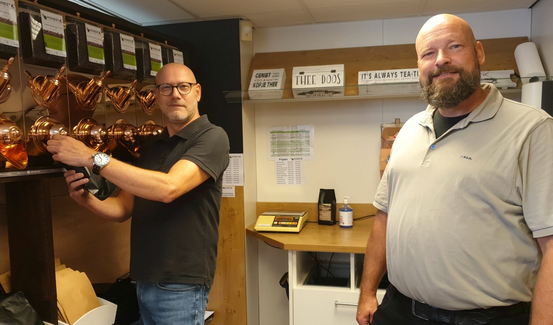 Jan Koster en Wim Bergsen bij de koperen koffiewand.