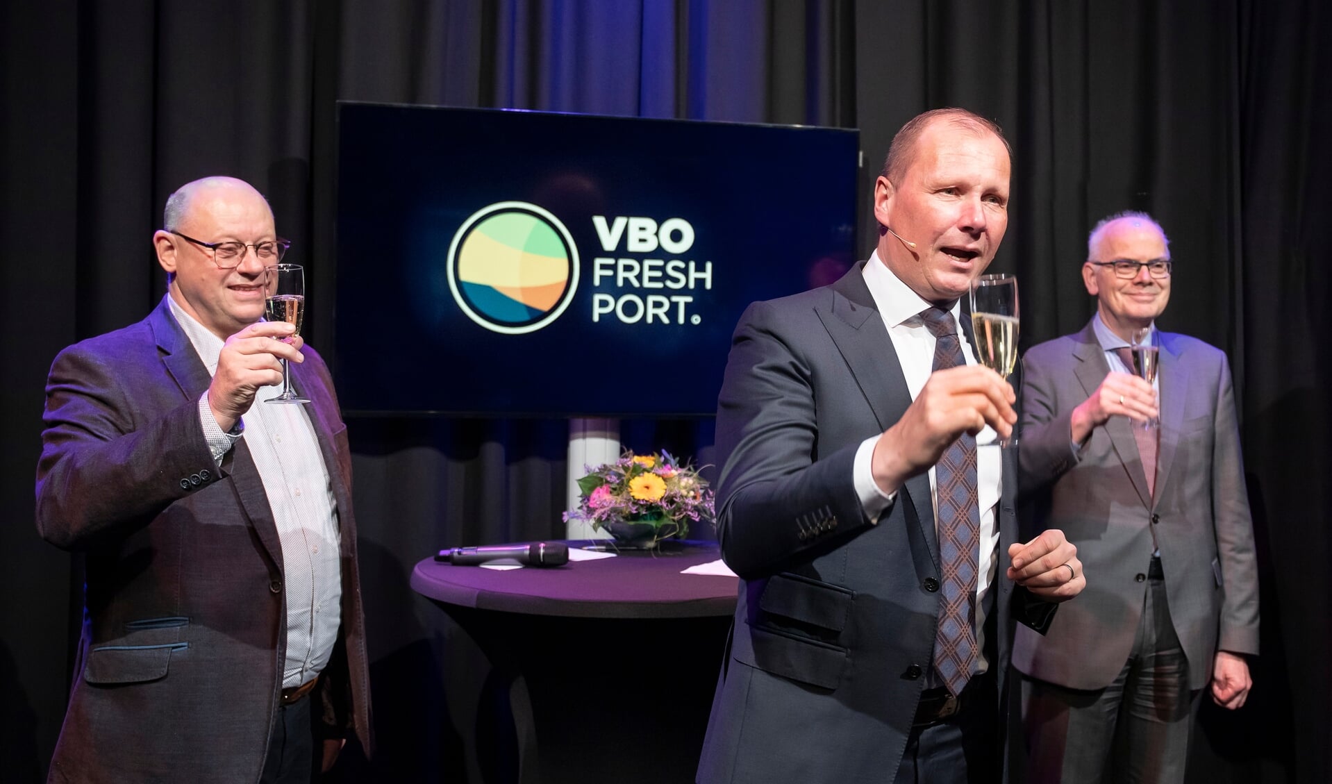 Bestuurslid Johan in 't Veld, voorzitter Jan Willem van Hellemond en burgemeester Jan van Belzen brengen een toost uit op het nieuwe jaar en de nieuwe naam. 