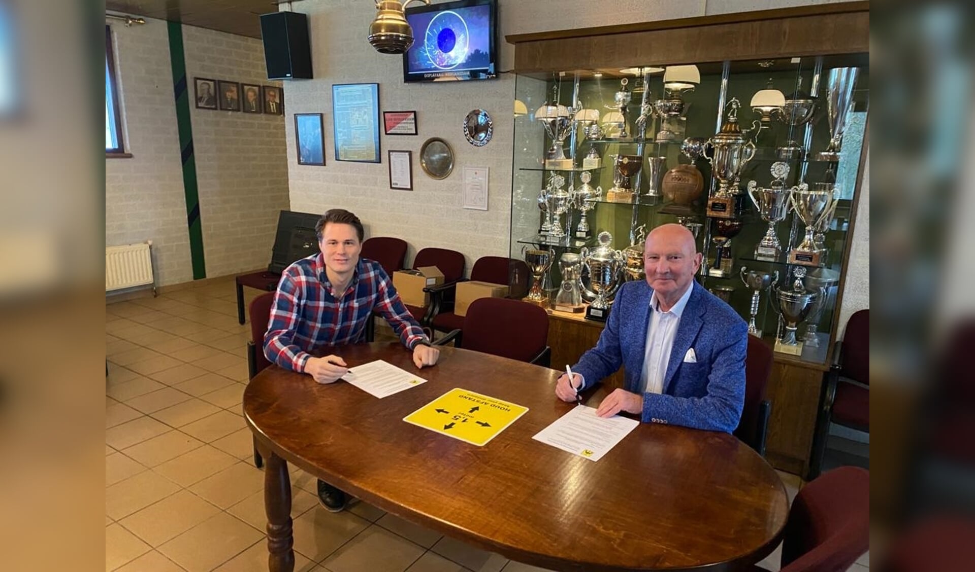 De ondertekening van het verlengde contract door Jonathan Jonk (links) en voorzitter Peter van der Linden.  